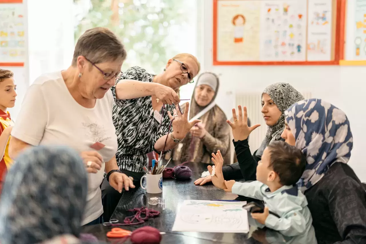 Frauen mit und ohne Kopftuch basteln zusammen