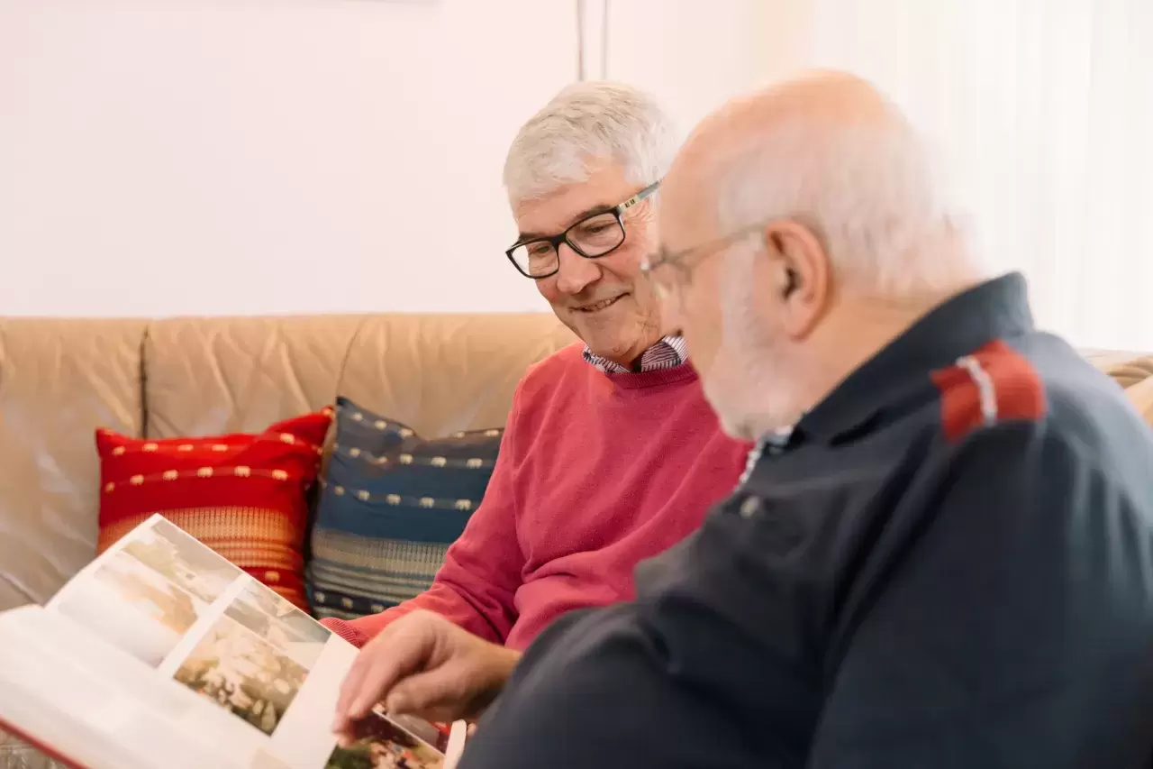 Zwei Senioren betrachten gemeinsam ein Buch.