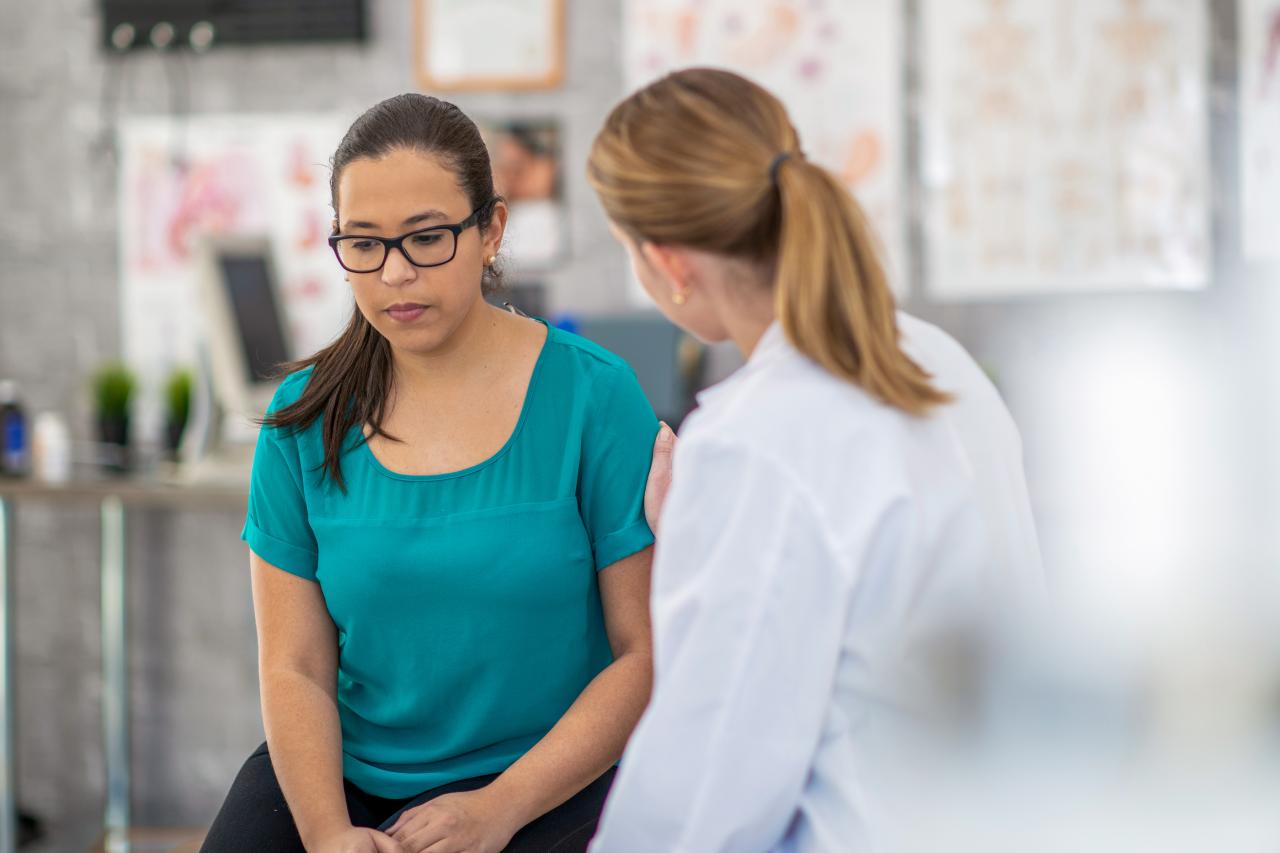 Une auxiliare de santé s'occupe d'une femme qui semble déprimée. 