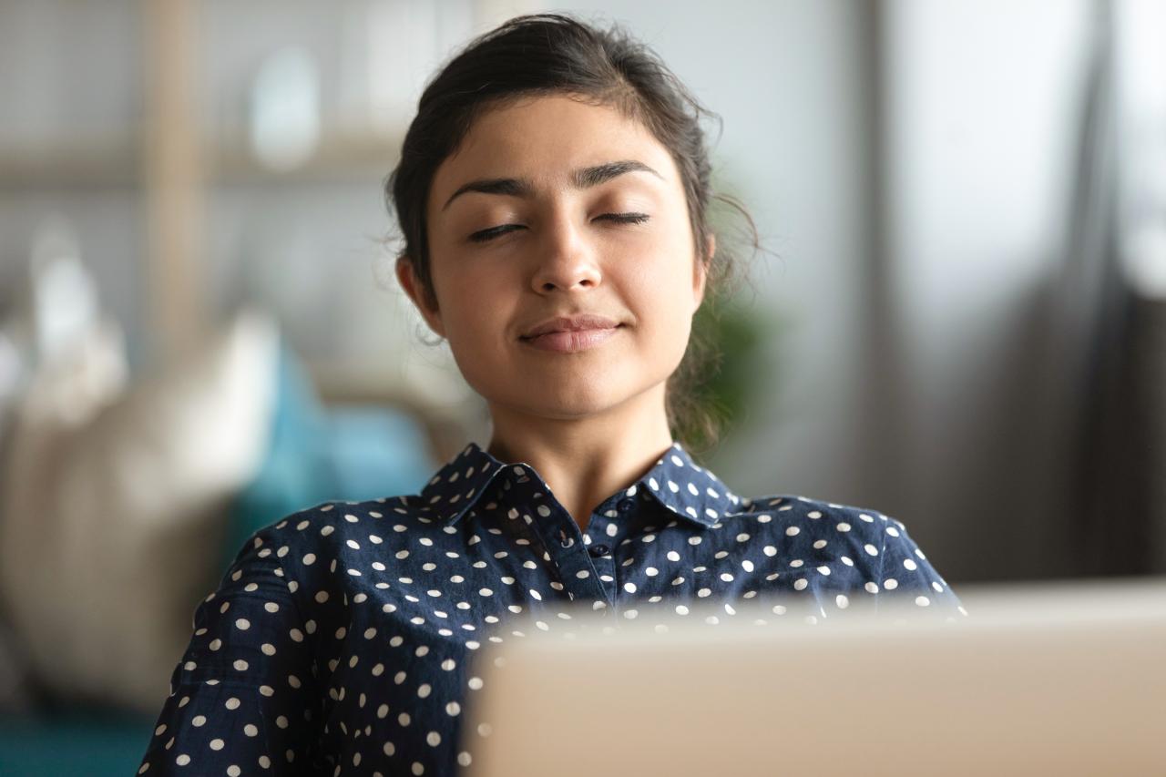 Eine Frau mit den Augen geschlossen und einem Lächeln im Gesicht