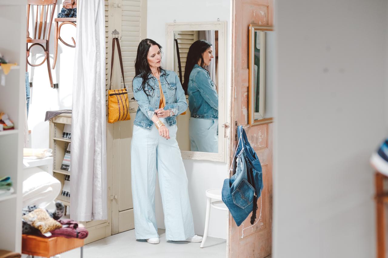 Eine Frau probiert eine Jacke an