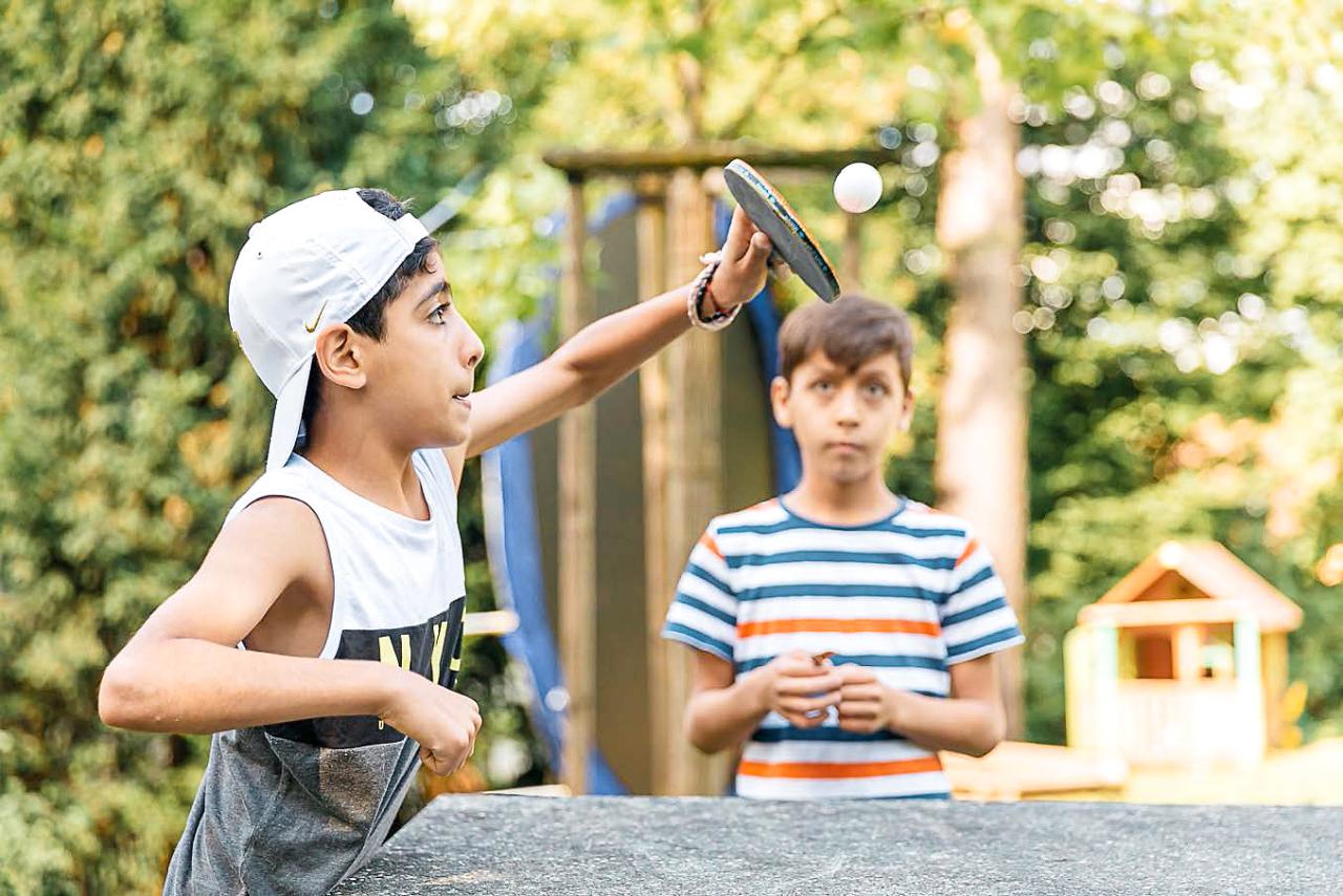Zwei Buben spielen Tischtennis im Gartn