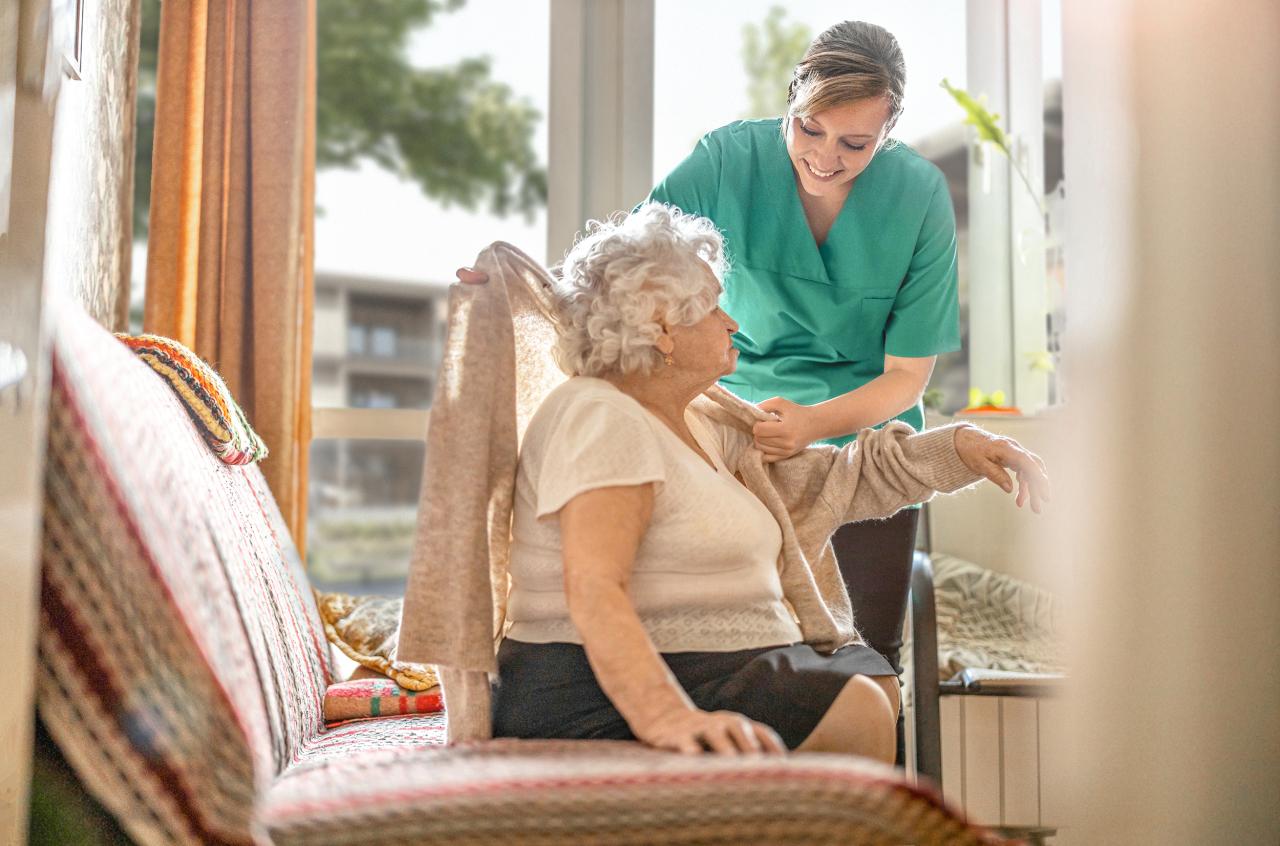 Pflegehelferin pflegt ältere Dame