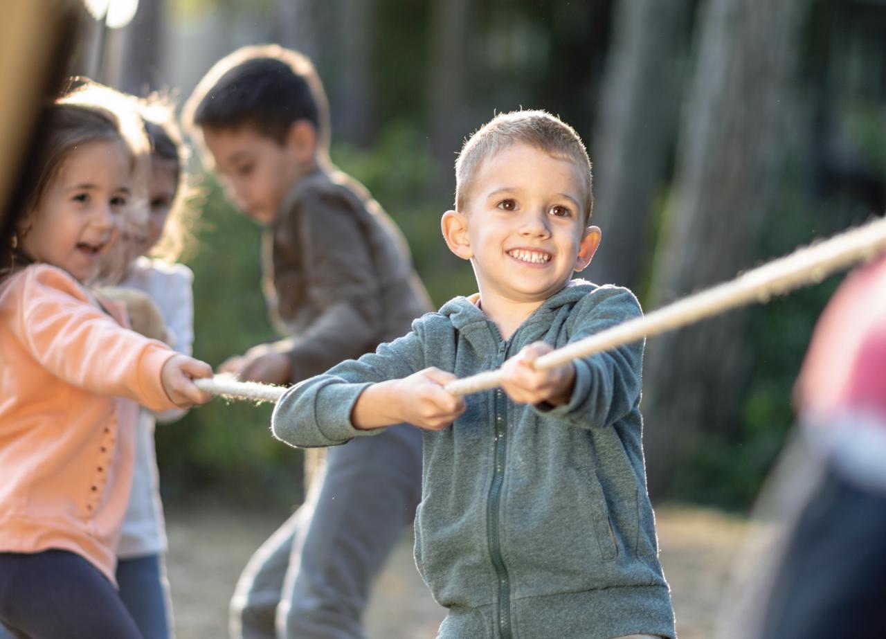 Tauziehen, lachende Kinder, mit Migrationshintergrund