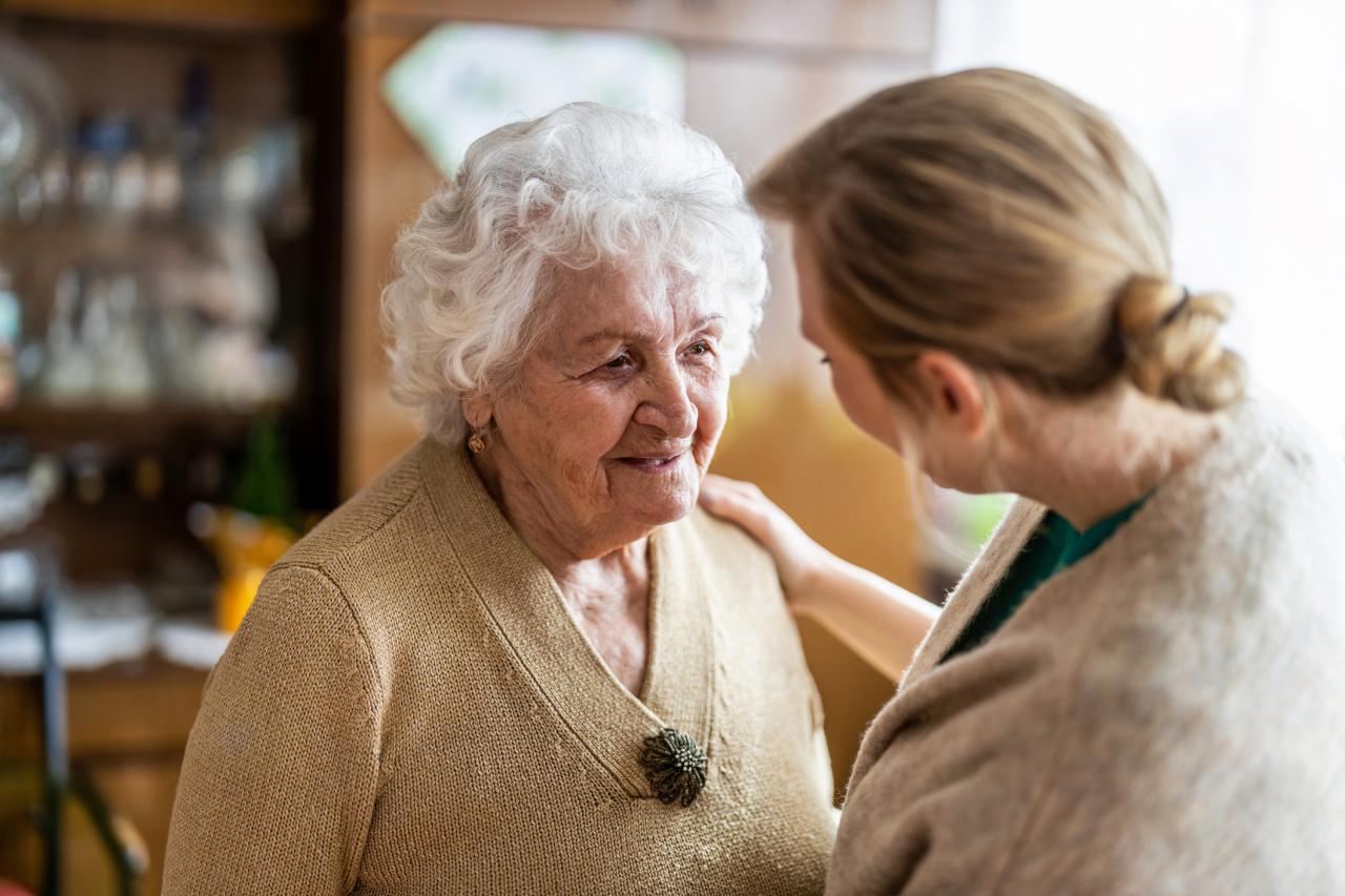 Eine freiwillige Person kümmert sich um eine ältere Frau.