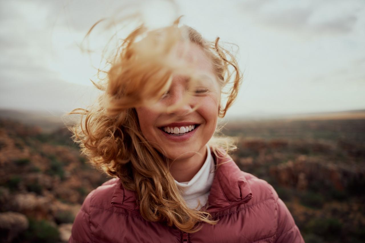 unbeschwerte, junge Frau mit Wind in den Haaren