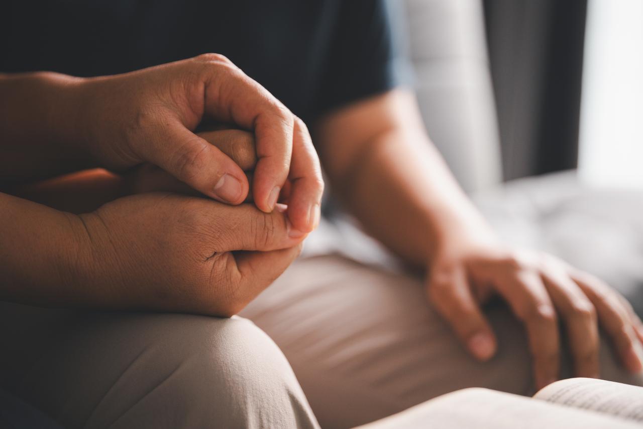 Person wird emotional unterstützt durch Hand halten