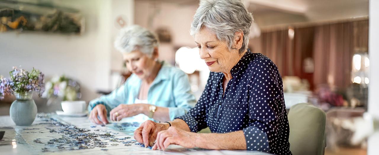 Zwei ältere Frauen machen ein Puzzle