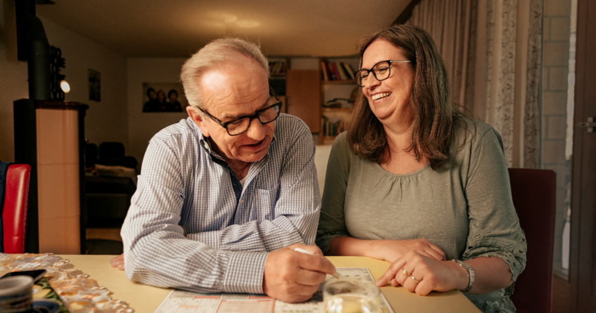 Frau und Herr lösen gemeinsam Rätsel in einem Heft