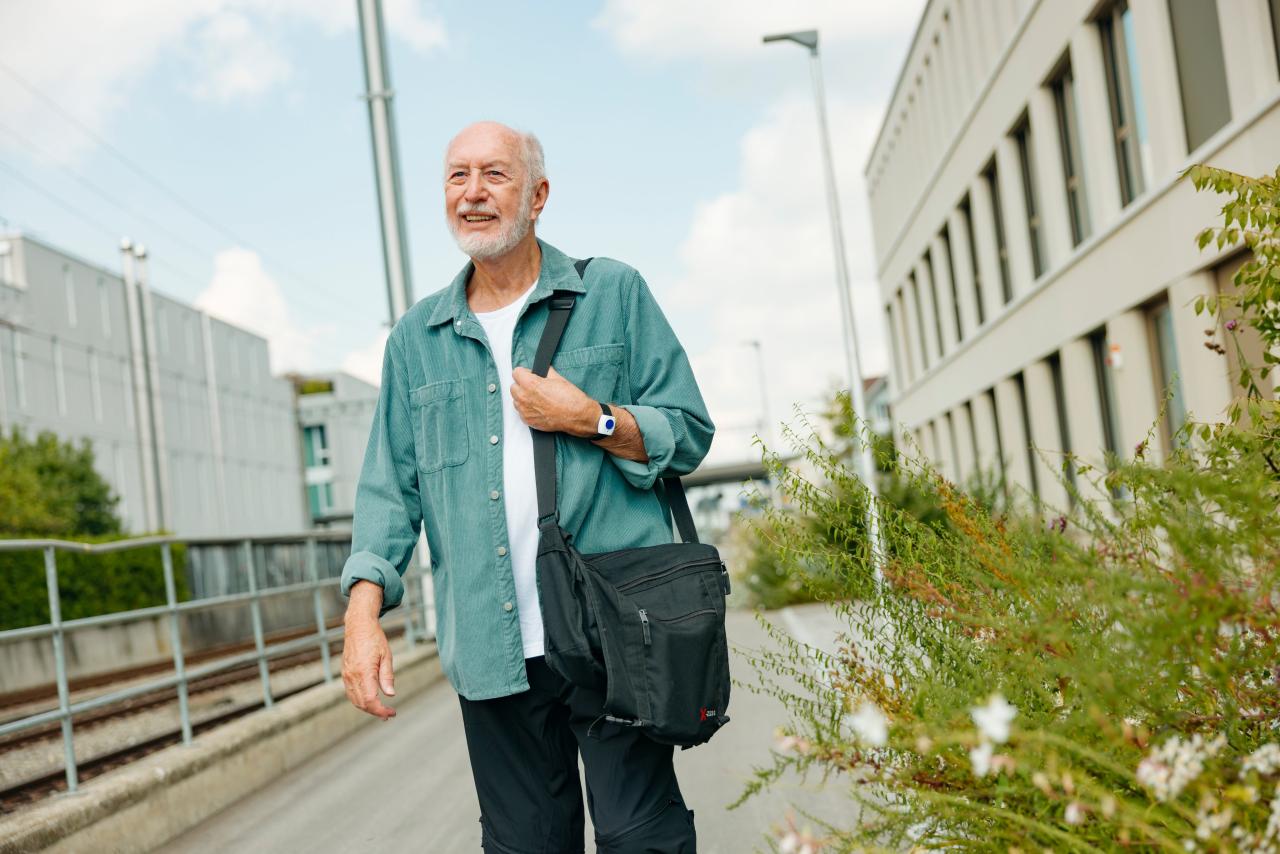 Älterer Mann unterwegs mit Notrufknopf am Handgelenk