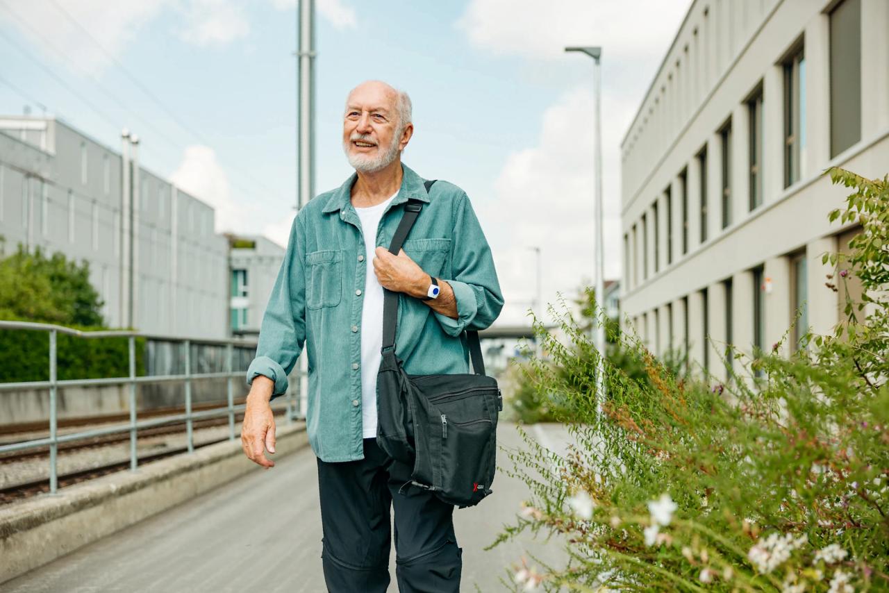 Älterer Mann unterwegs mit Notrufknopf am Handgelenk