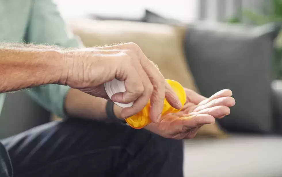 Close-up von einem Händepaar, das einen Tablettenbehälter öffnet.
