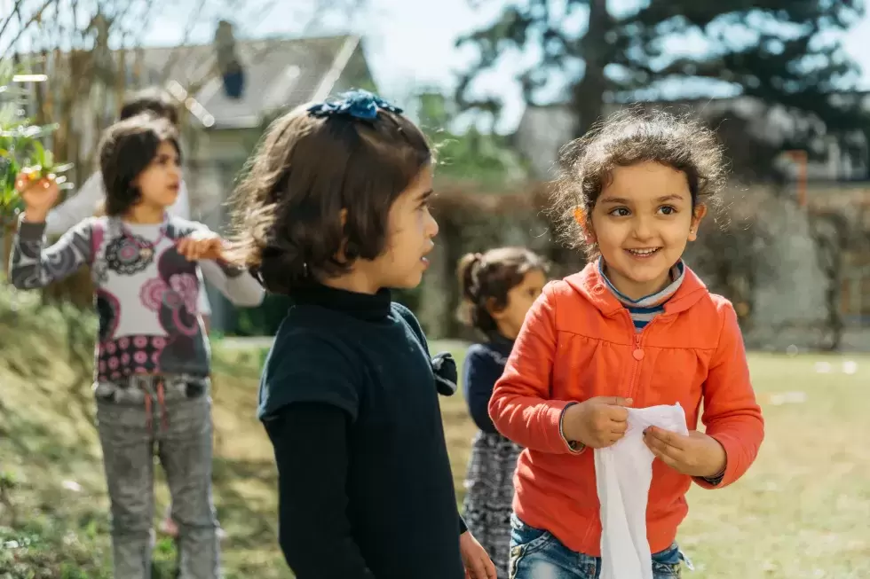 Glückliche Kinder mit Migrationshintergrund im Garten