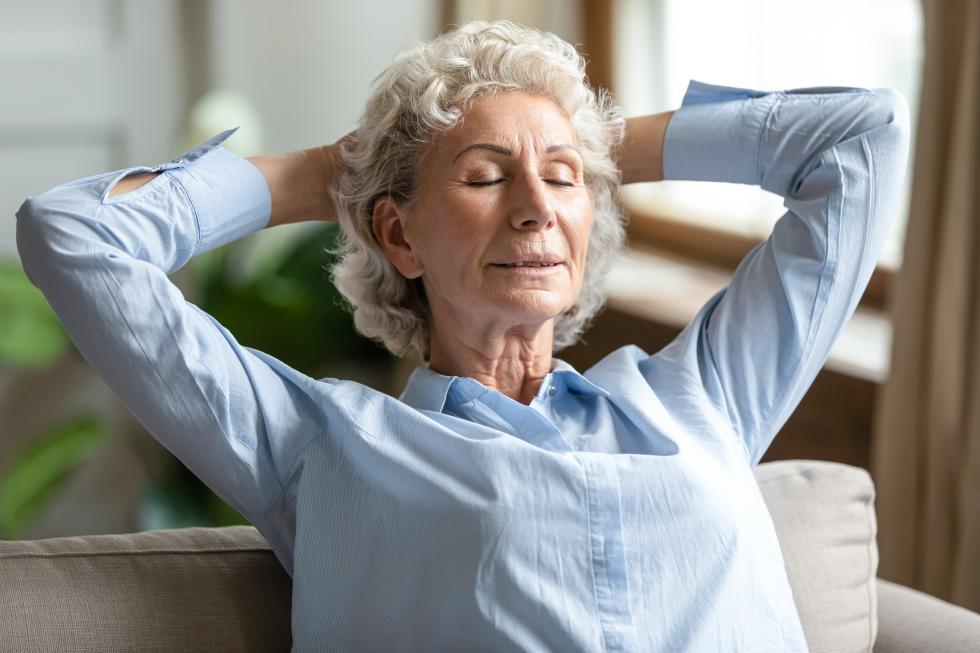 Une dame d'un certain âge s'assoit en arrière pour se détendre.