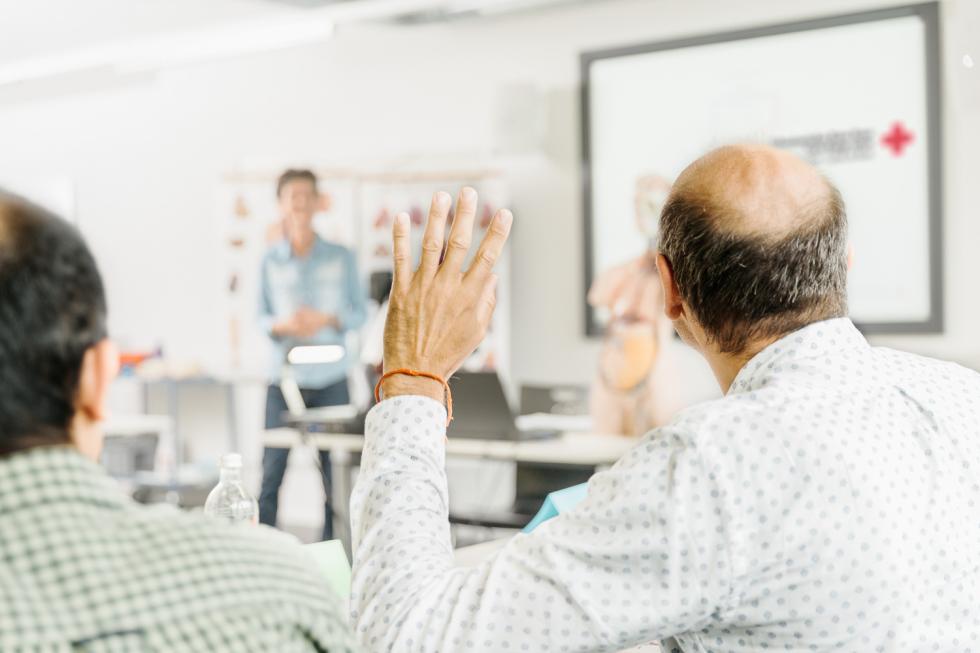 Ein Mann meldet sich im Unterricht mit Handaufstrecken zu Wort