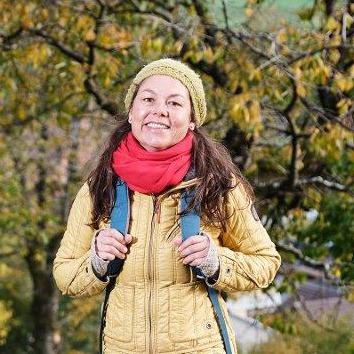 Lachende Ergotherapeutin unterwegs zu einem Klienten im hügeligem Emmental