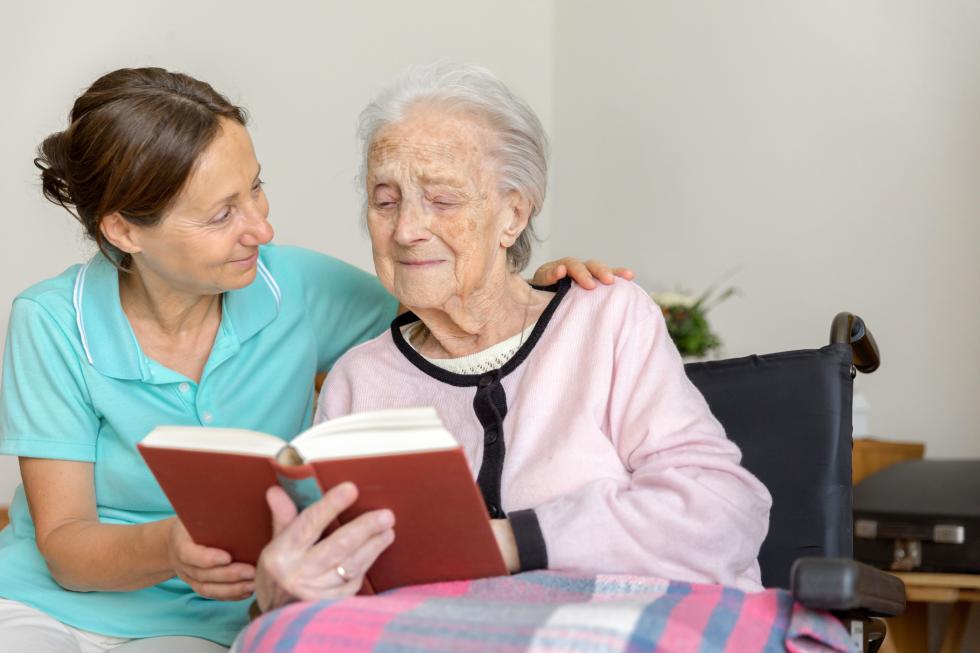 Jüngere und ältere Frau lesen zusammen ein Buch